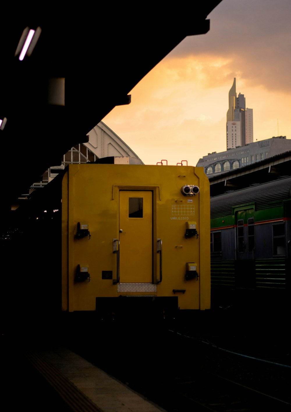 a yellow box sitting on the side of a train track