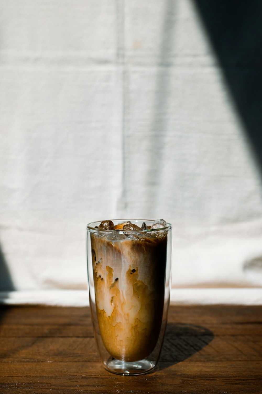 a cup of coffee sitting on top of a wooden table