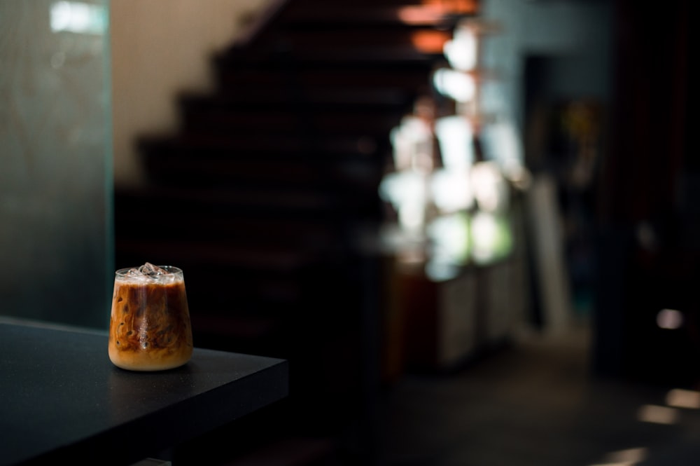 uma bebida sentada em cima de uma mesa ao lado de uma caixa de escada