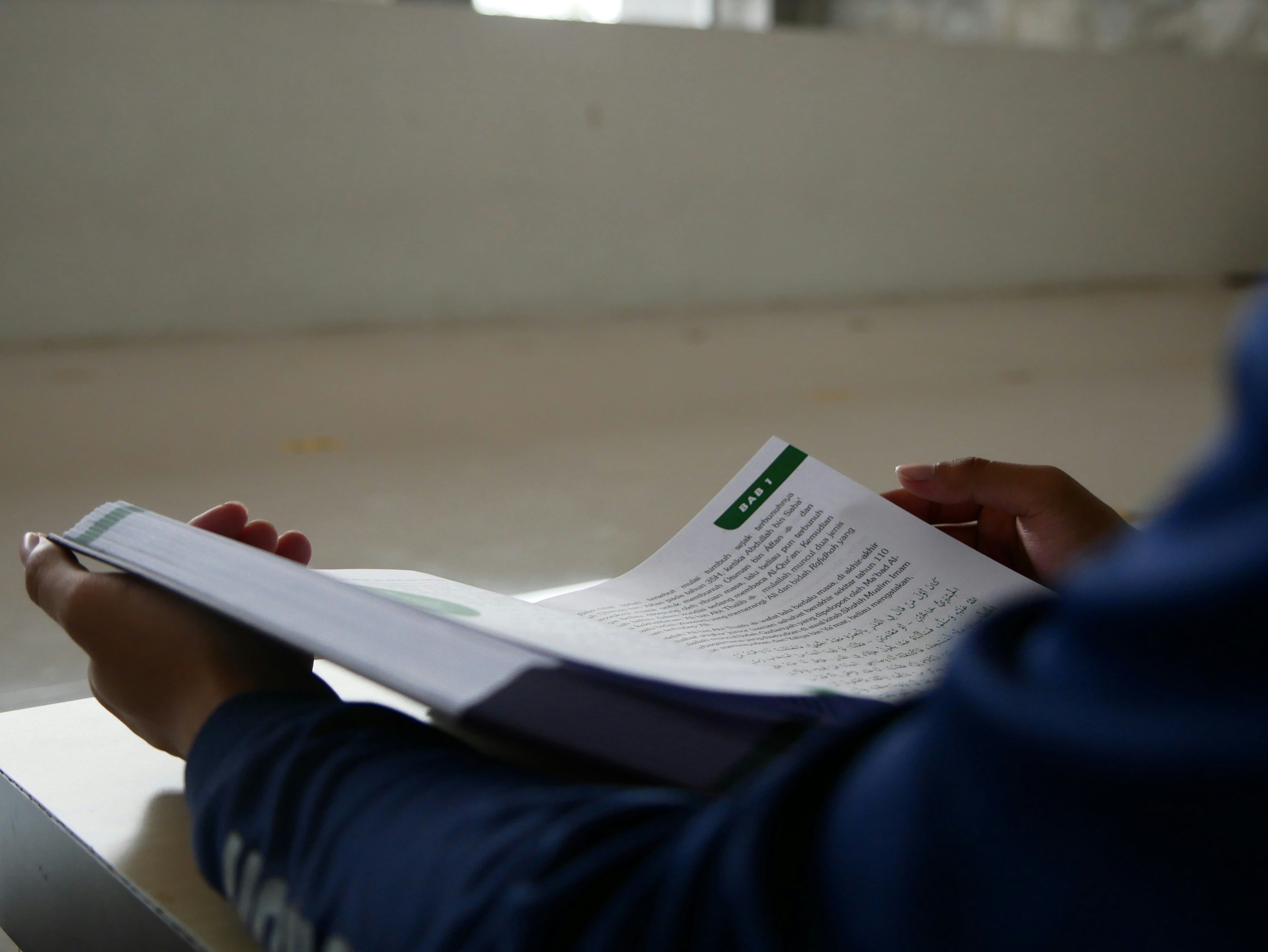 a person sitting at a table reading a book