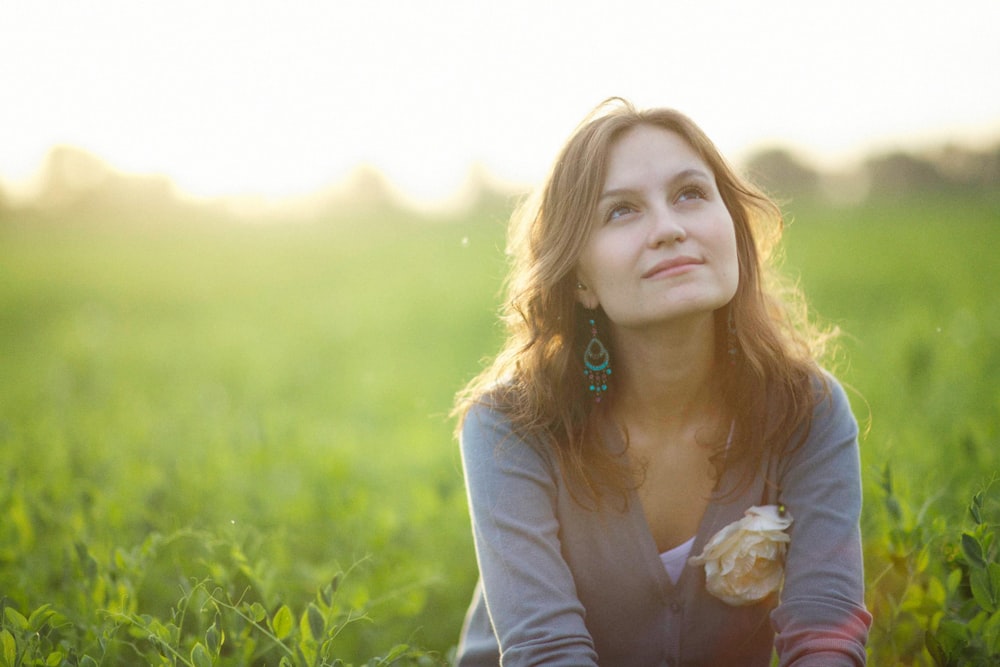 a woman sitting in a field of green grass