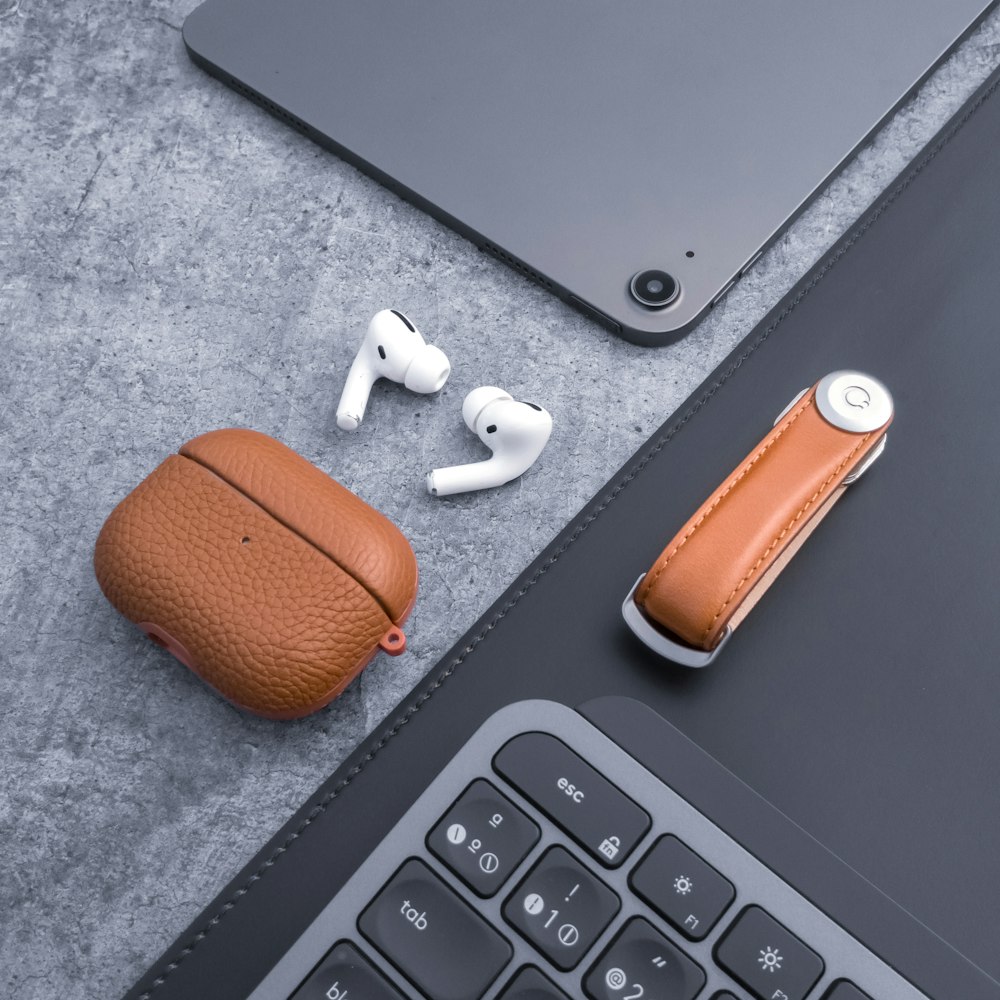 a pair of ear buds sitting next to a laptop