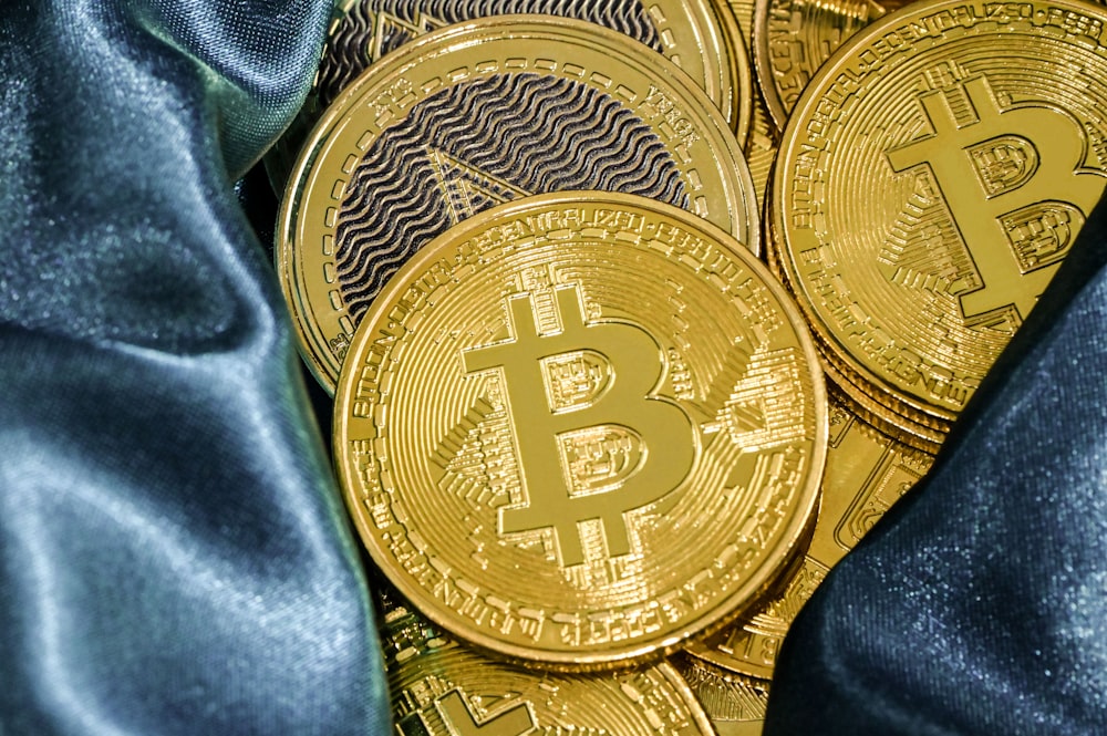 Ein Haufen goldener Bitcoins sitzt auf einem blauen Tuch