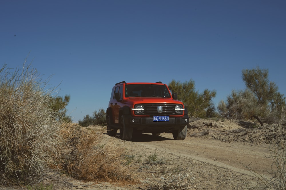 a red truck driving down a dirt road