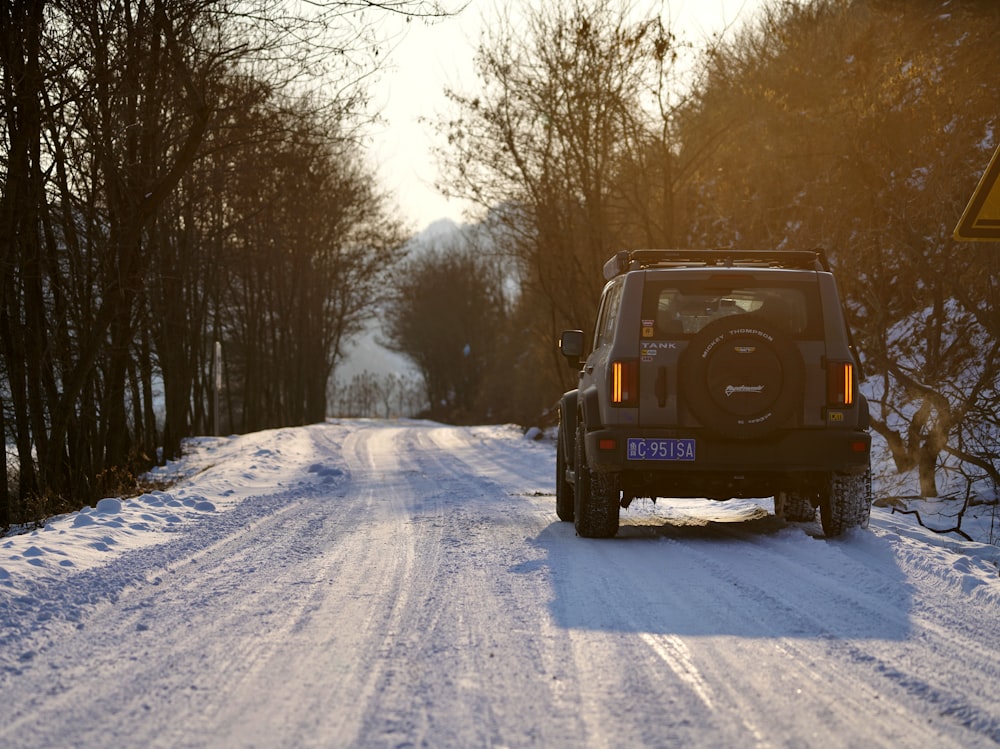 a jeep driving down a snow covered road