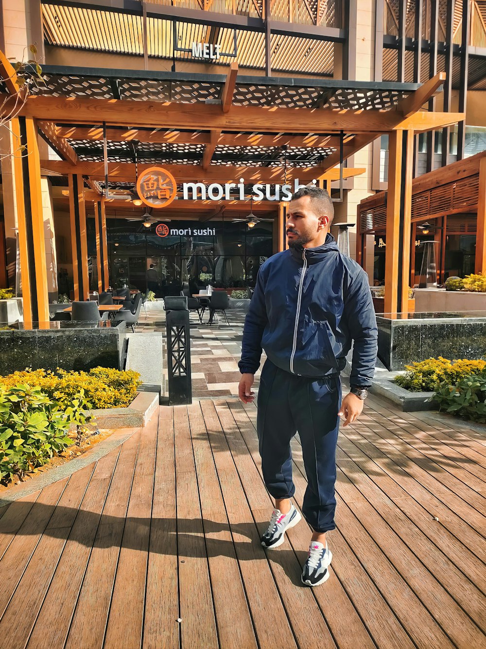 a man standing on a boardwalk in front of a hotel
