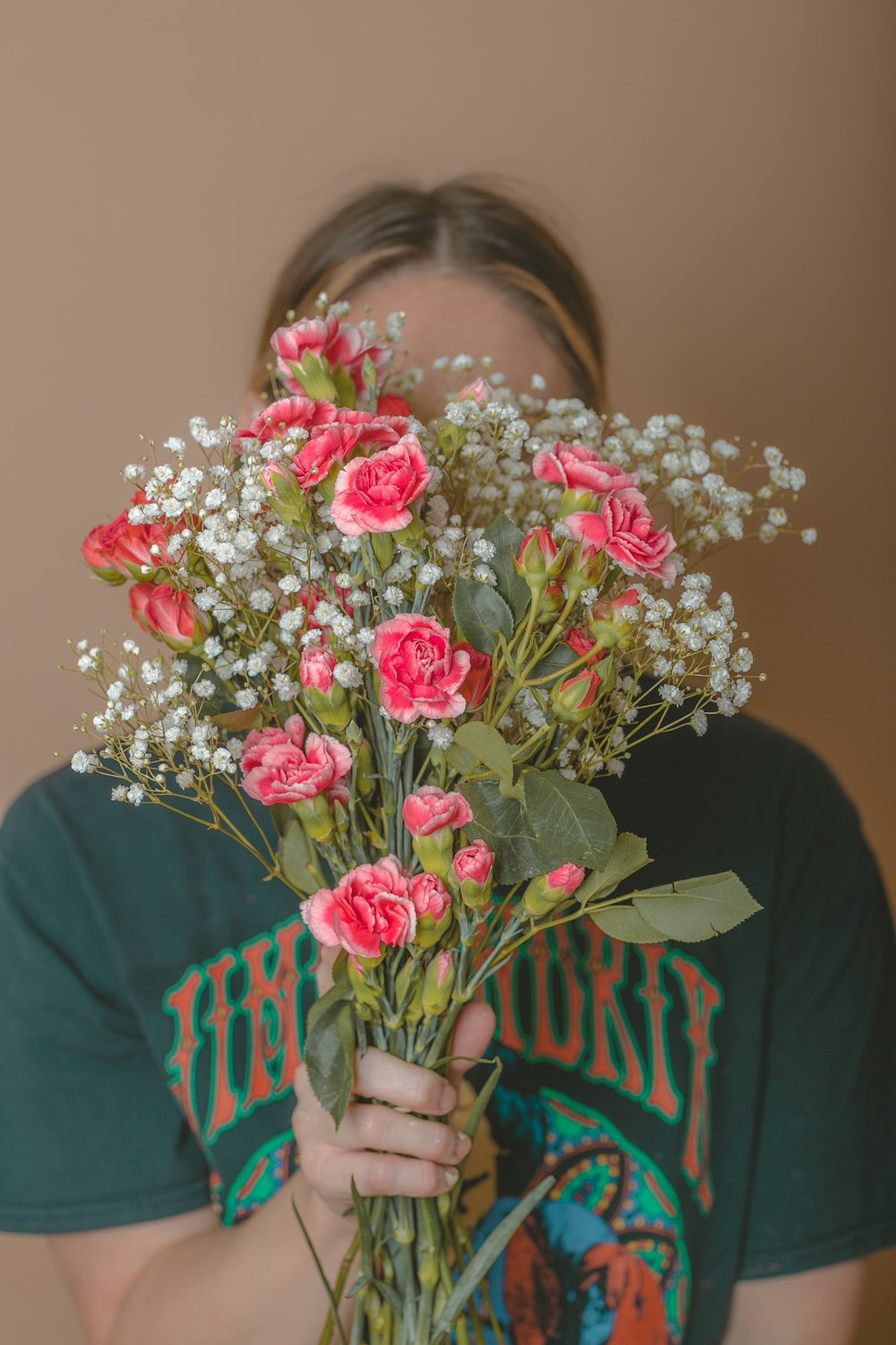 a woman holding a bunch of flowers in her hands