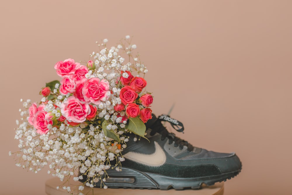 a bouquet of flowers sitting on top of a pair of sneakers