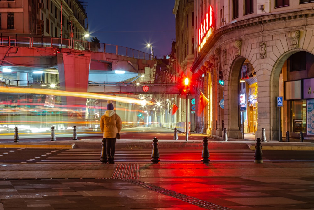 a man standing in the middle of a street at night