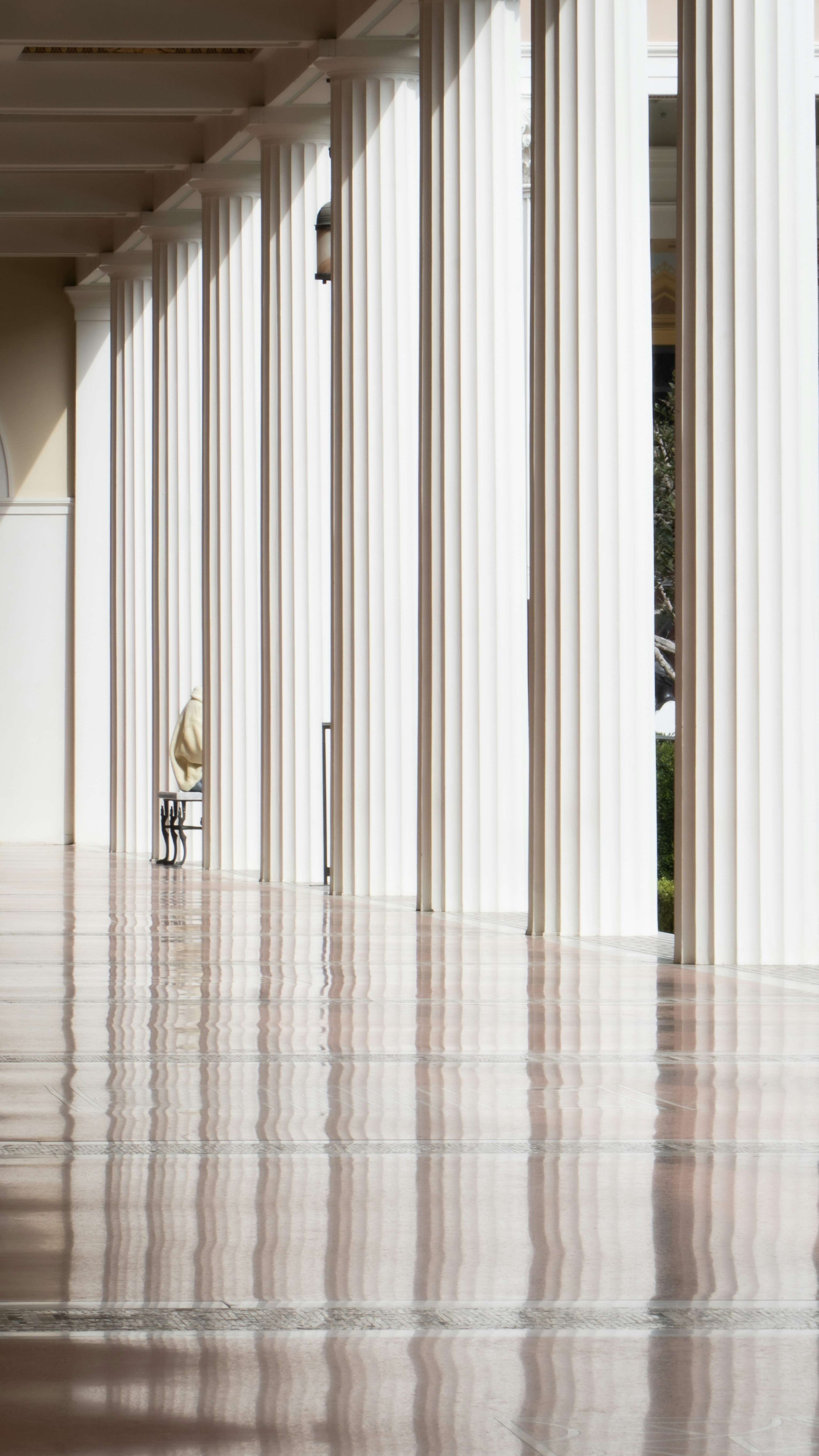 ein Raum mit Säulen und einer Uhr auf dem Boden