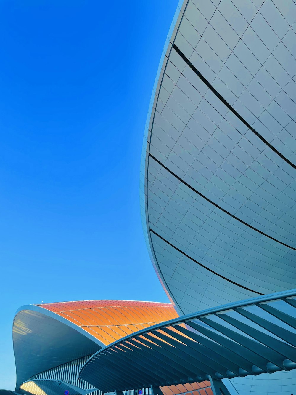 a building with a curved roof and a blue sky in the background