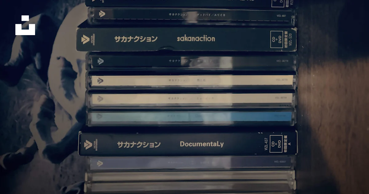 A stack of dvds sitting on top of a wooden table photo – Free Grey ...