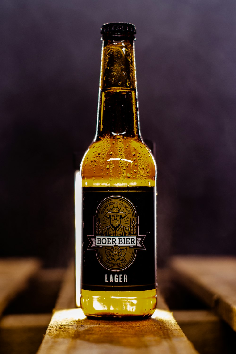 a bottle of beer sitting on top of a wooden table