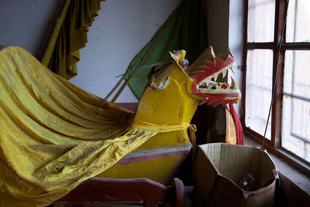 a yellow horse statue sitting next to a window