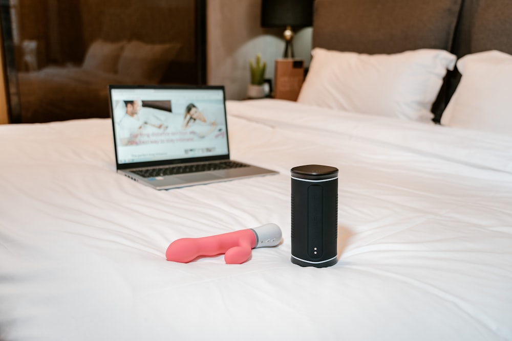 a laptop computer sitting on top of a white bed