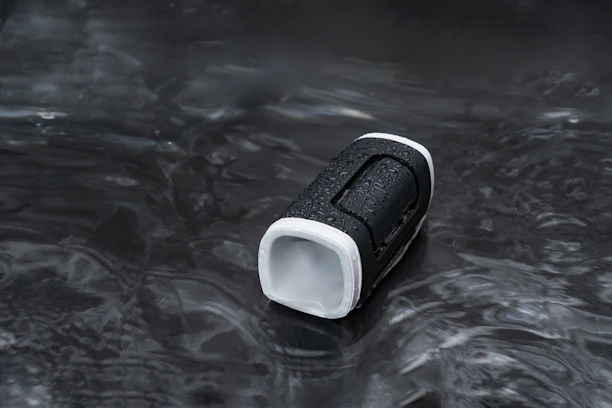 Close-up of a crepuson speaker with water droplets, capturing its rugged, outdoor-ready design
