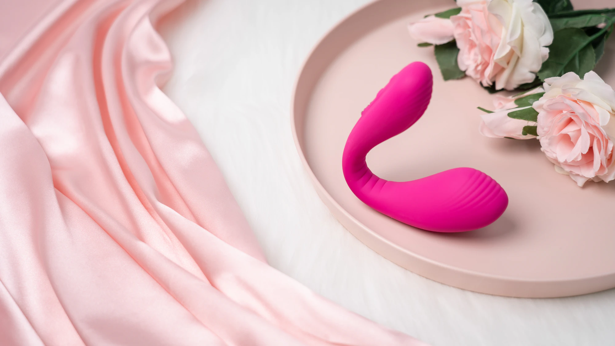 Pink couples massager on a tray with flowers