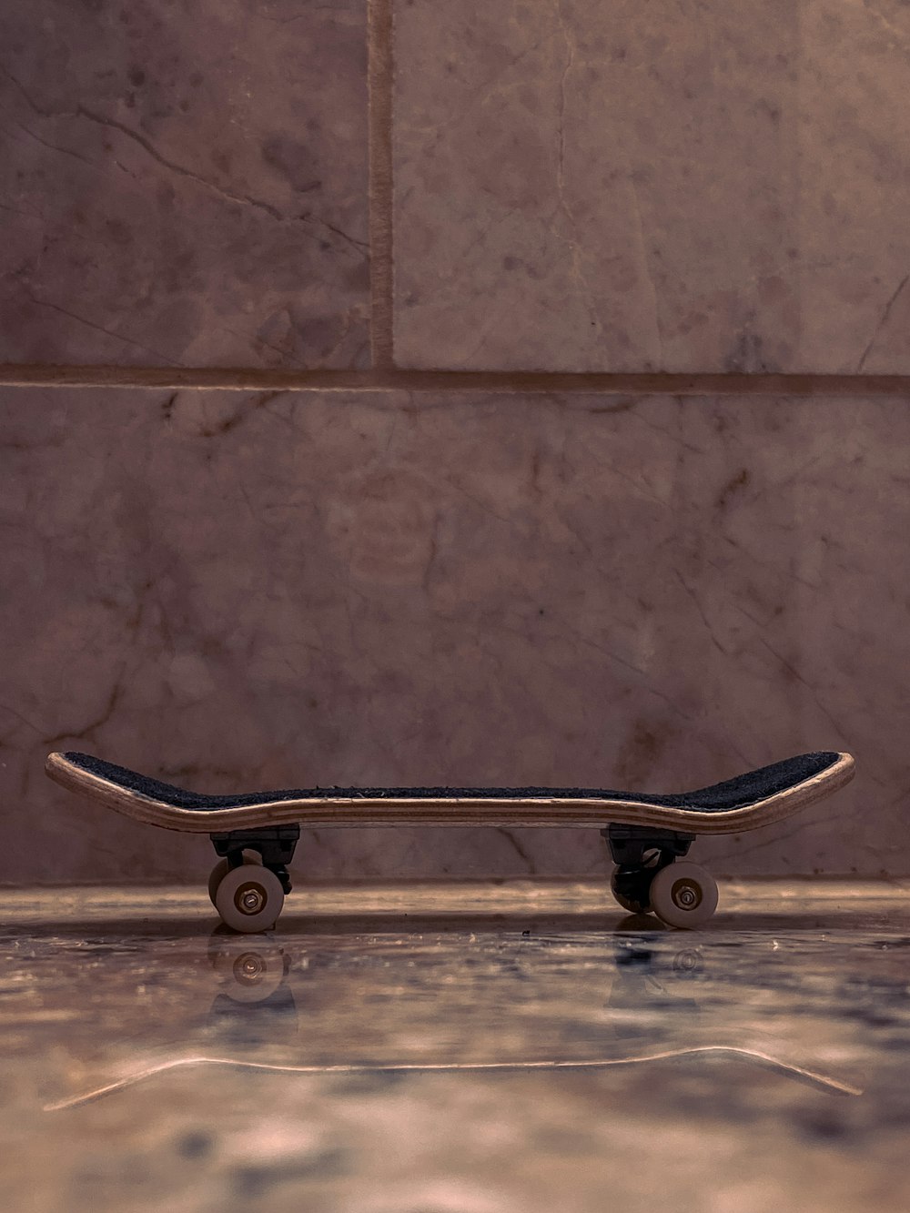 a skateboard sitting on the ground in front of a wall
