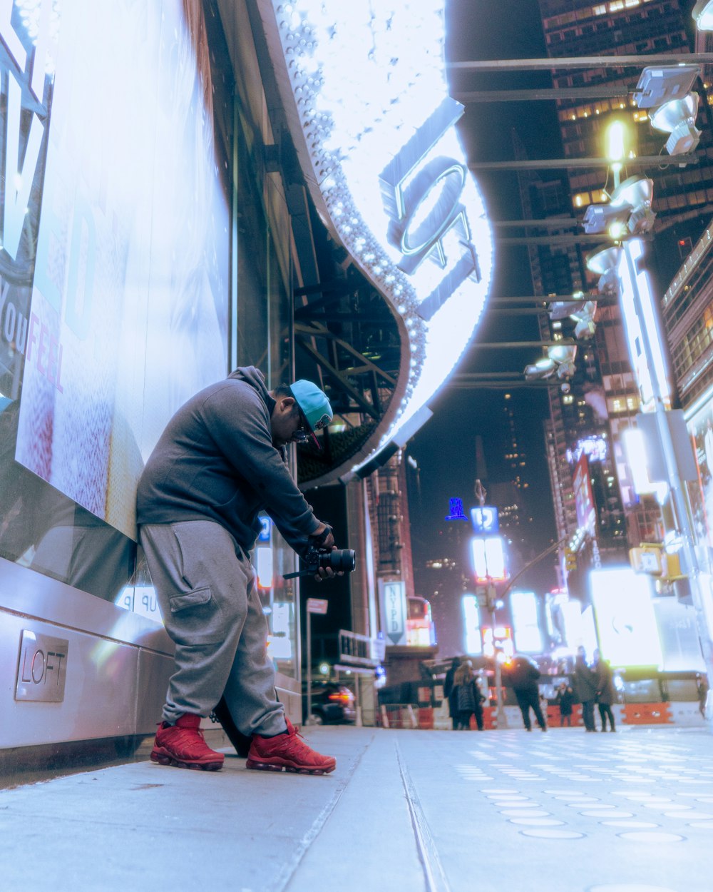 a man leaning against a wall on a city street