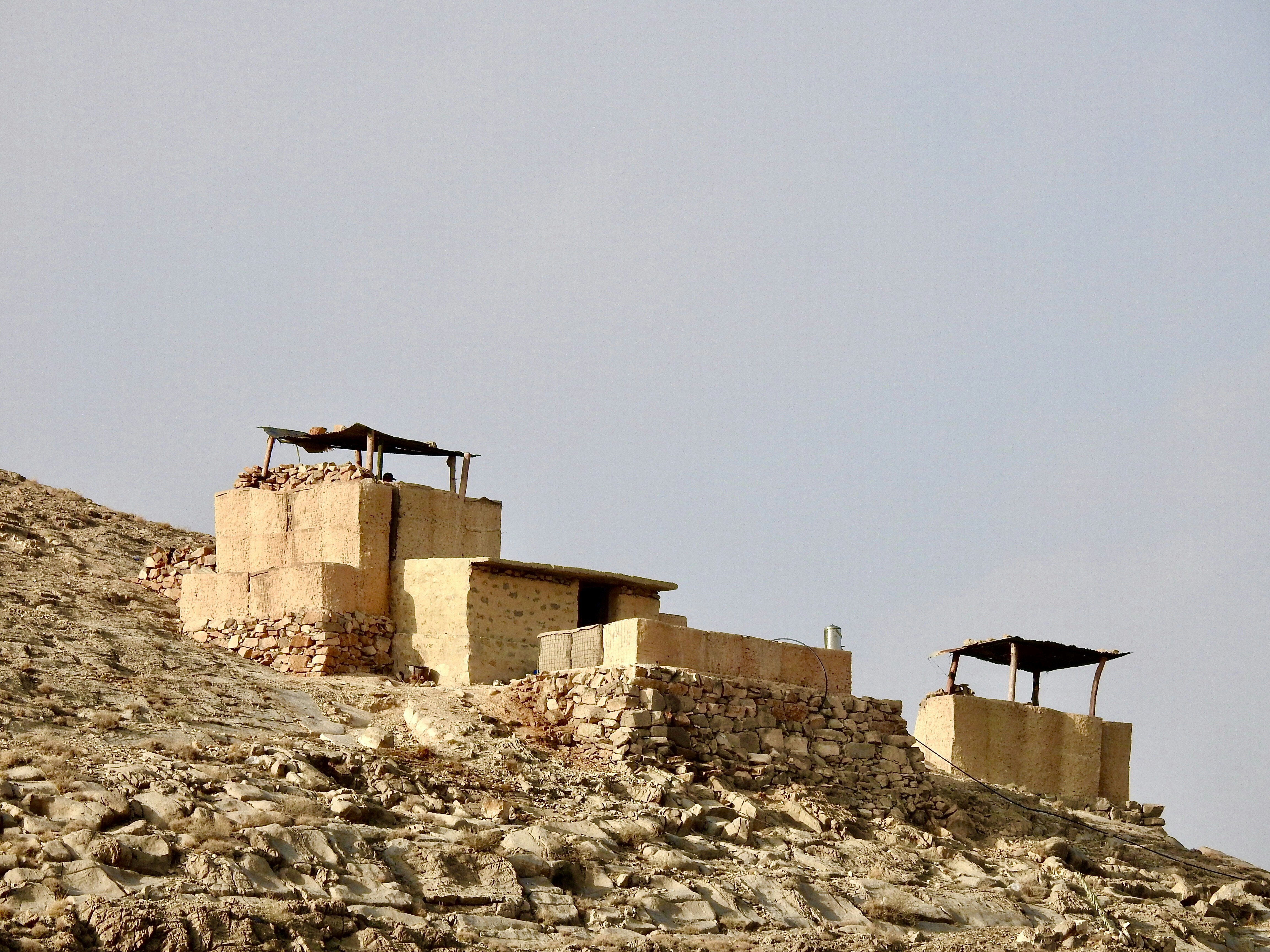a couple of buildings sitting on top of a rocky hill