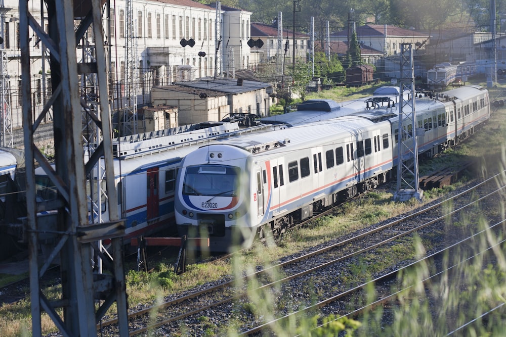 a train traveling down train tracks next to tall buildings