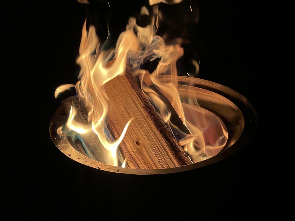 um fogo queimando dentro de uma tigela de madeira