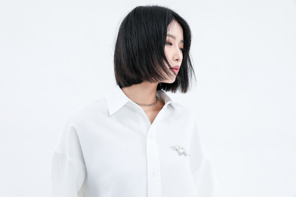 a woman with black hair wearing a white shirt