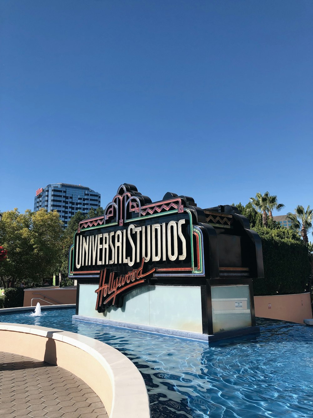 the universal studios sign in front of a pool