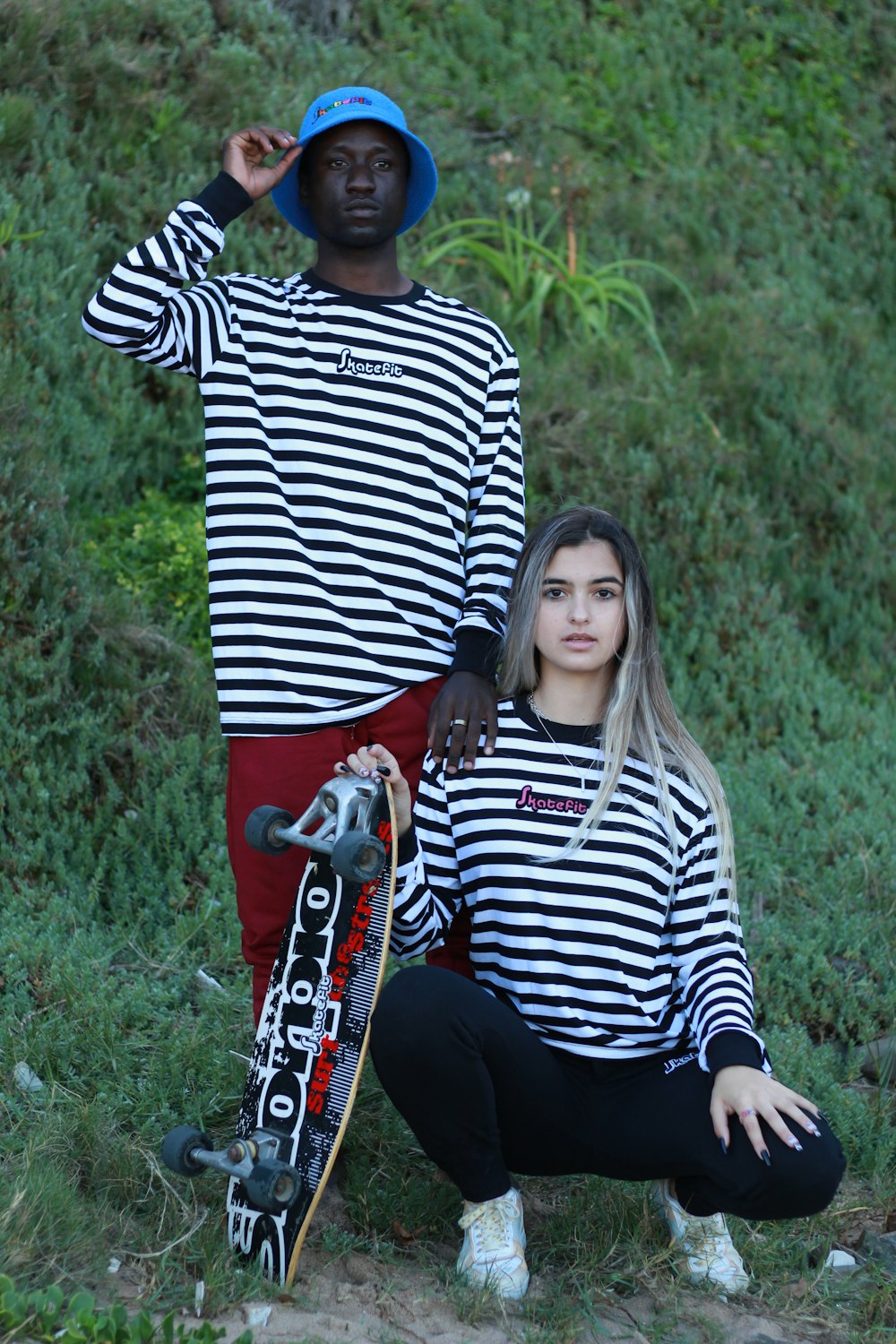 a man and a woman are posing with their skateboards