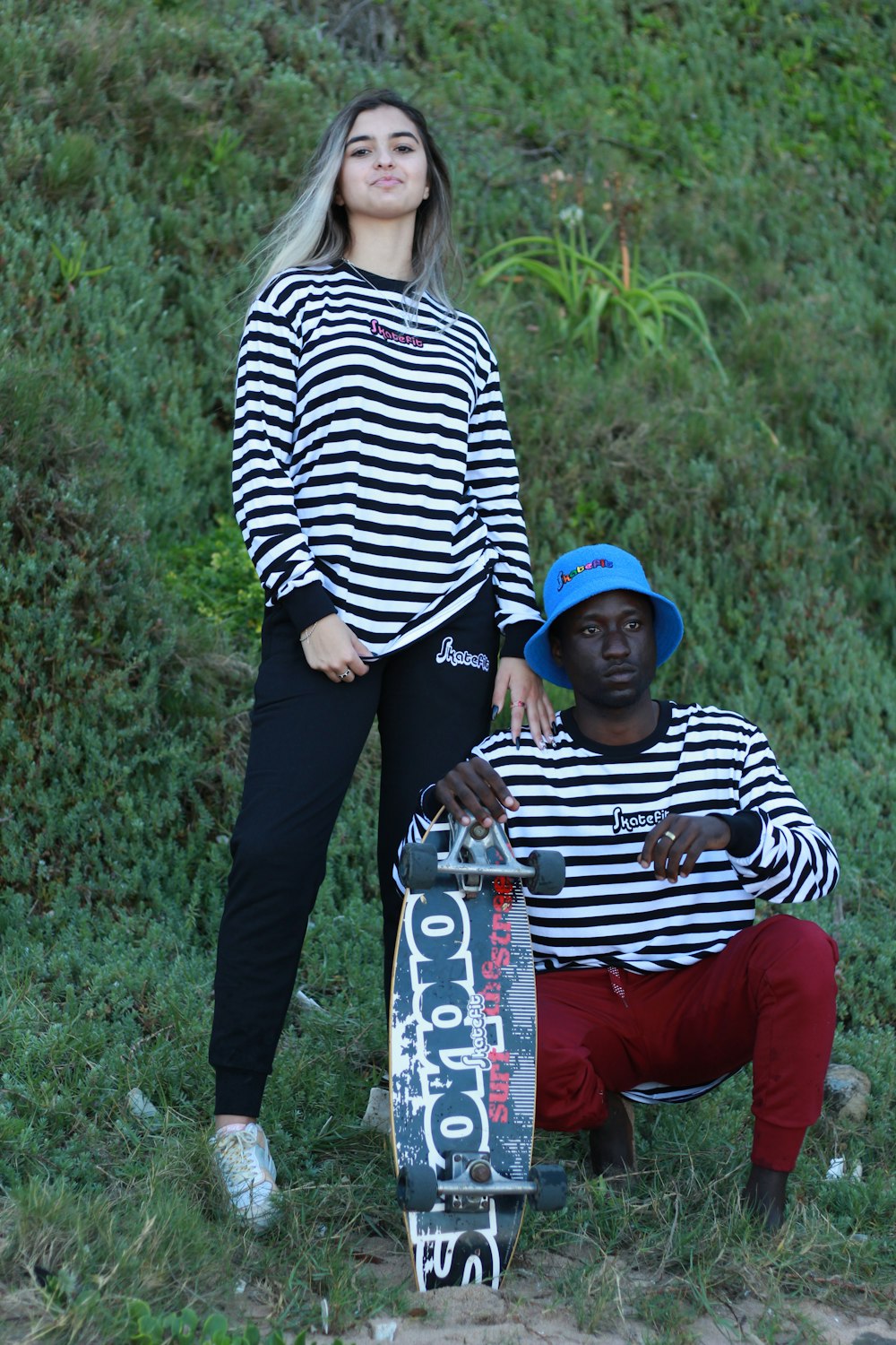 a couple of people standing next to a skateboard