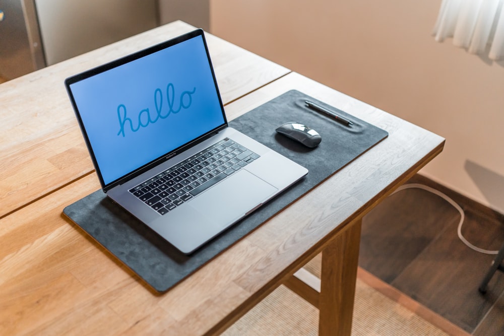 a laptop computer sitting on top of a wooden desk