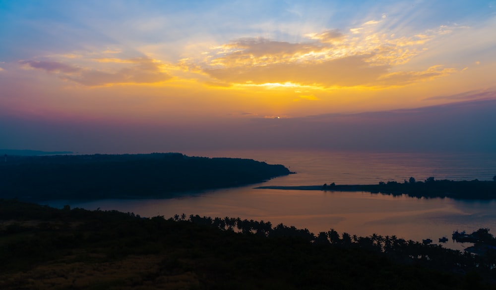 the sun is setting over a body of water