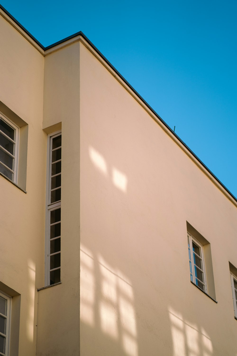 a building with three windows and a blue sky in the background