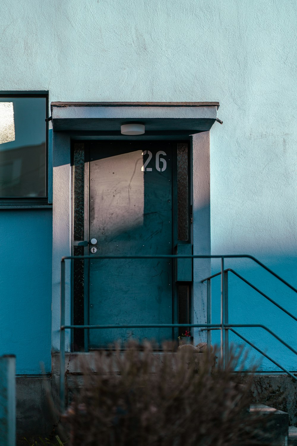 a blue building with a door and a window