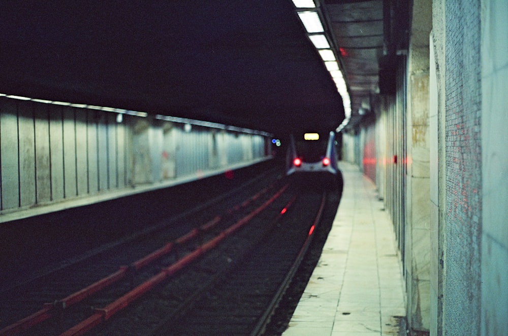 a train traveling down train tracks next to a tunnel