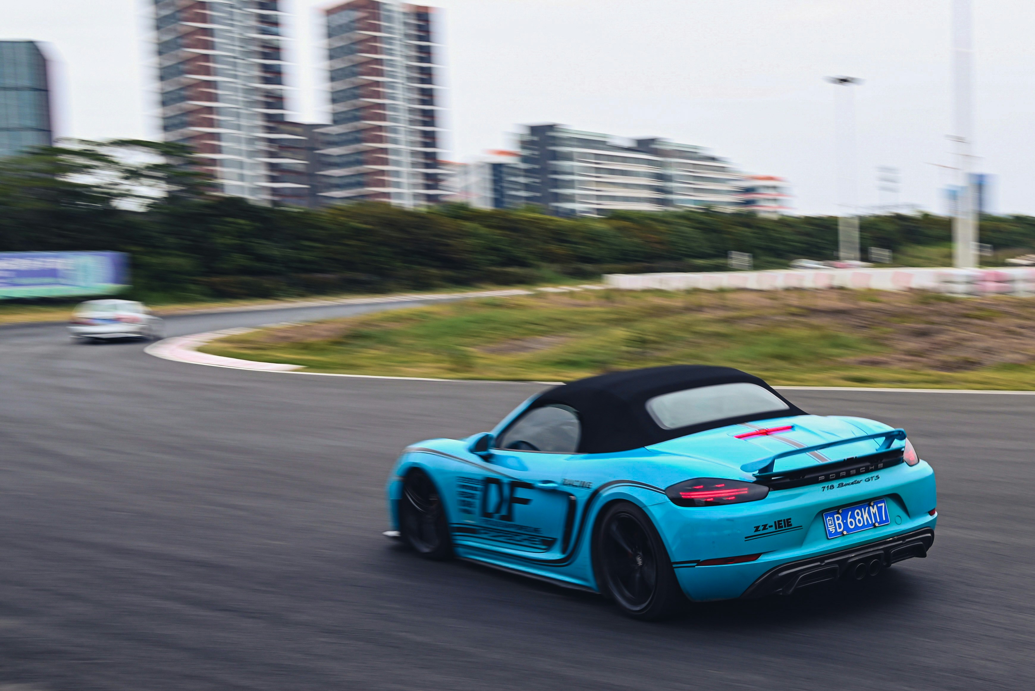 a blue sports car driving down a race track