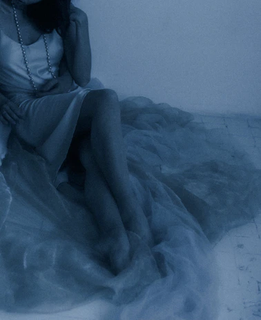A softly lit velvet dress draped over a vintage Parisian chair under moonlight.