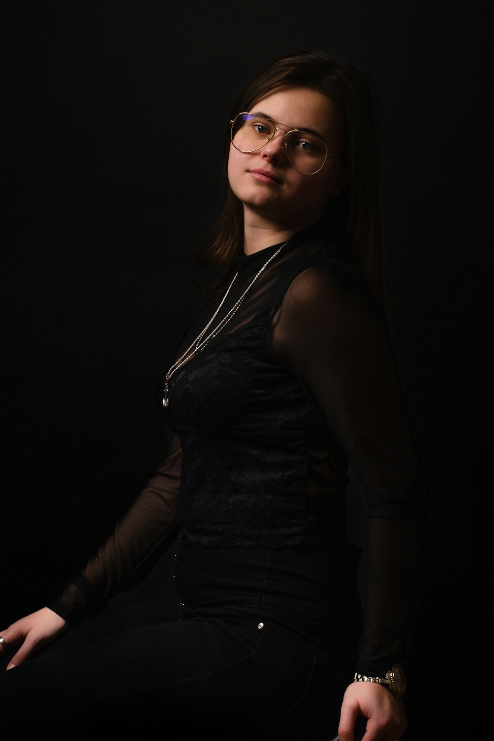 a woman wearing glasses sitting on a chair