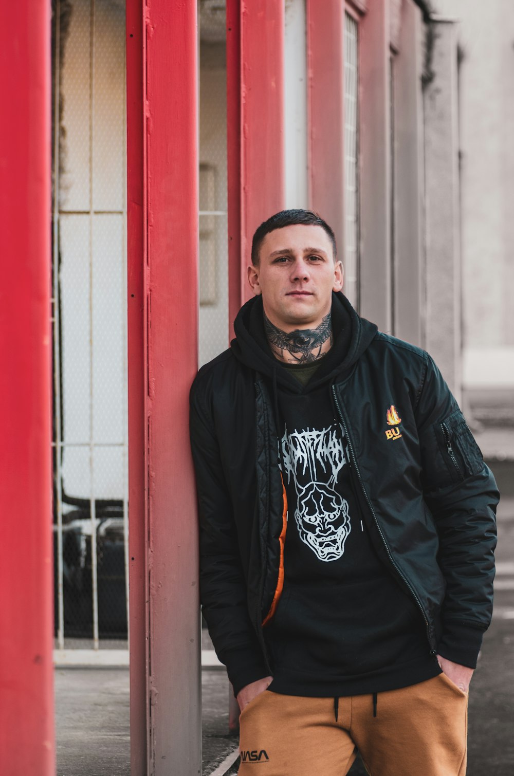 a man leaning against a pillar with a tattoo on his face