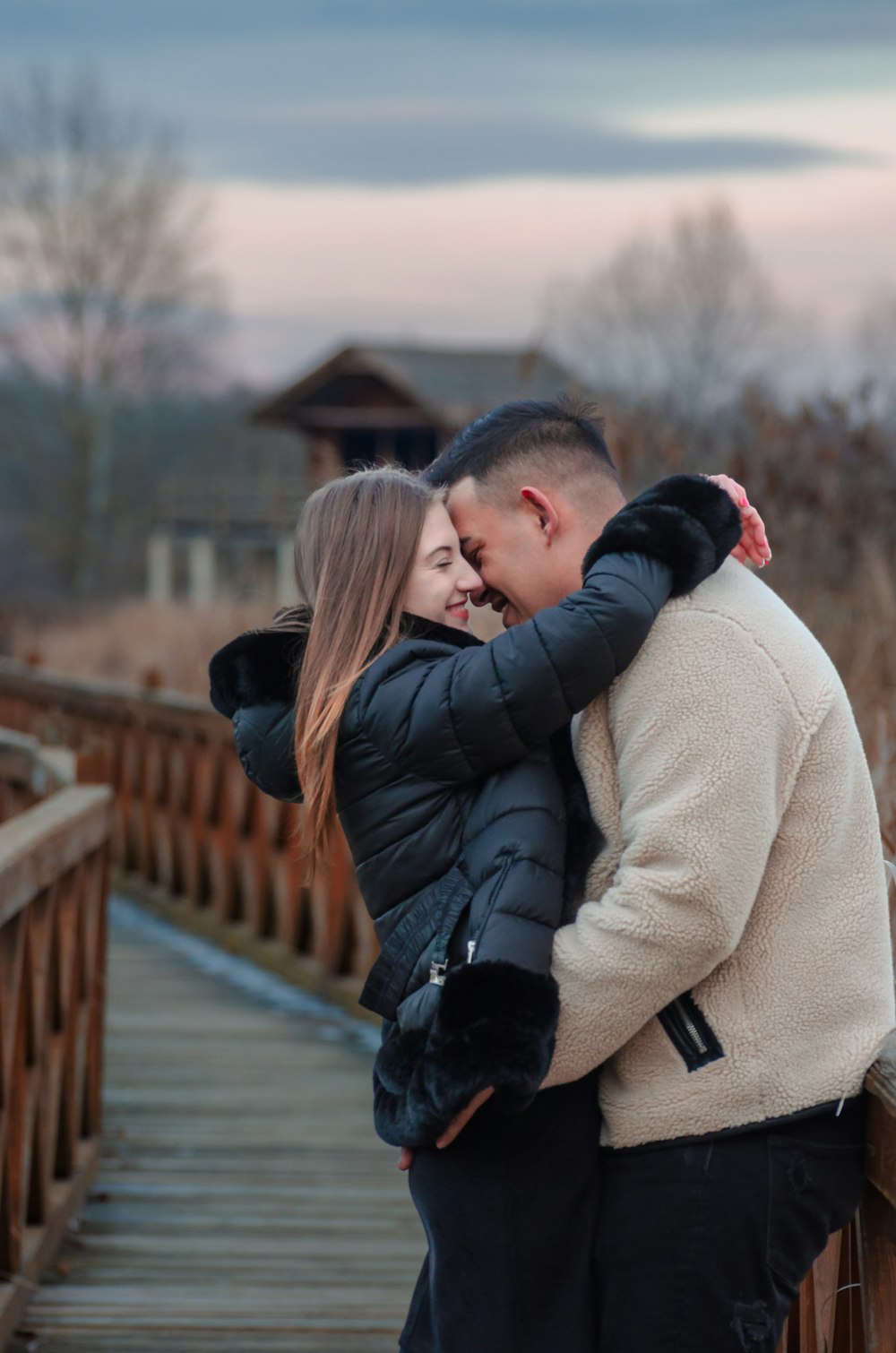 a man and a woman embracing on a bridge
