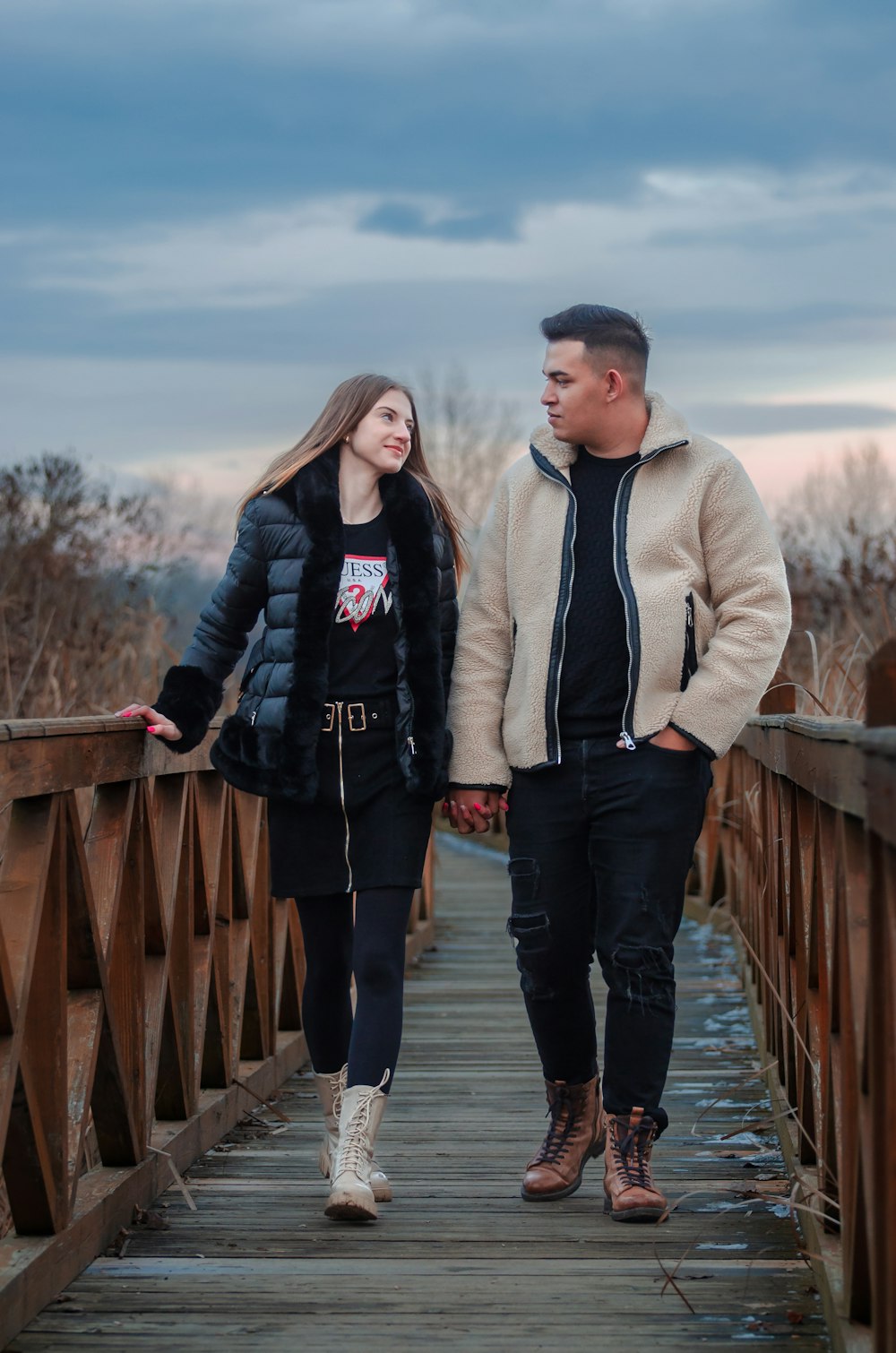 a man and a woman walking across a bridge