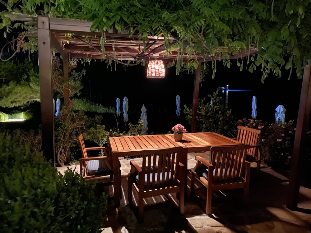 a wooden table sitting under a pergolated roof