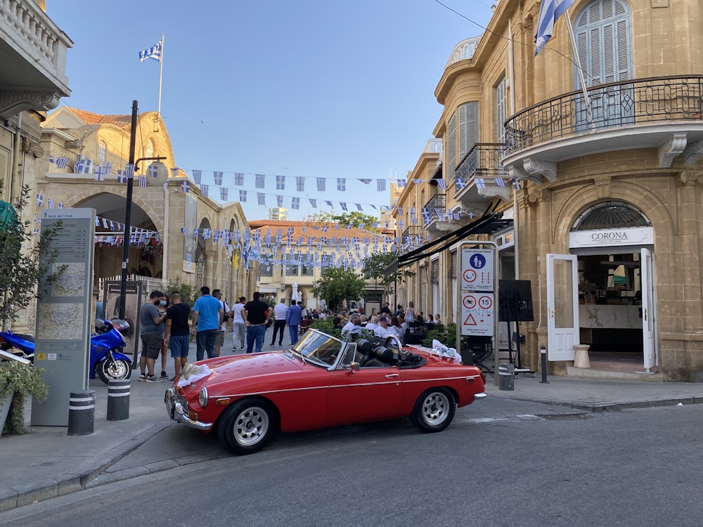 Un coche rojo aparcado al costado de una calle