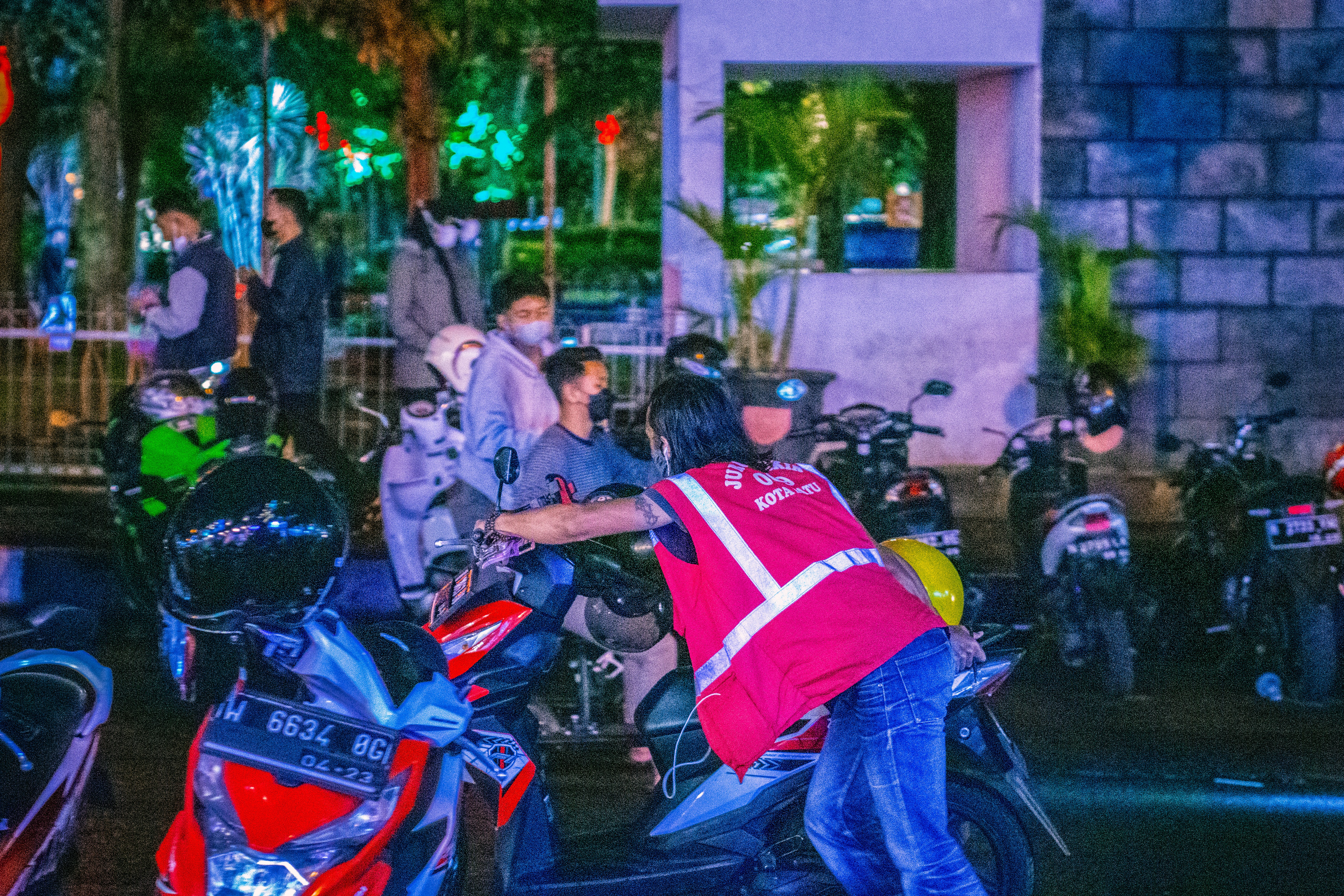 sekelompok orang berdiri di sekitar sepeda motor yang diparkir