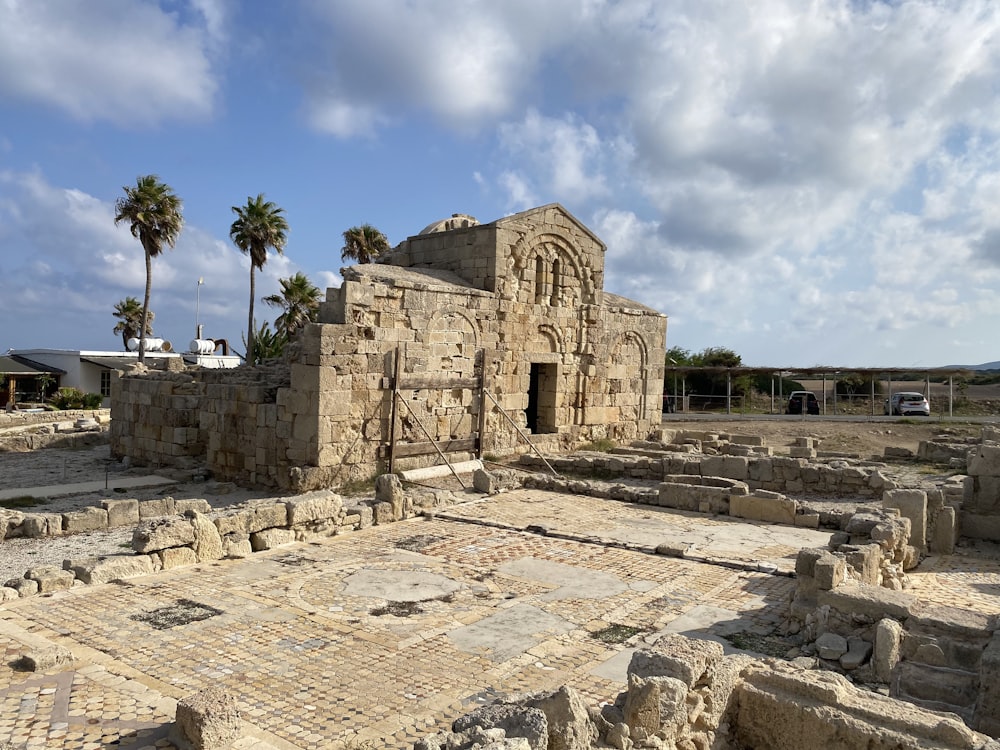 the ruins of a roman city with palm trees in the background