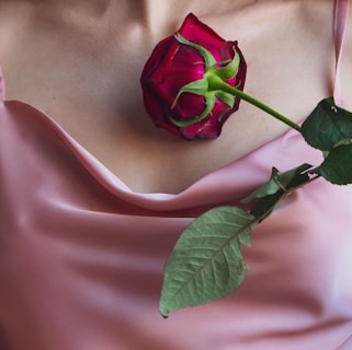 a rose that is laying on a woman's chest