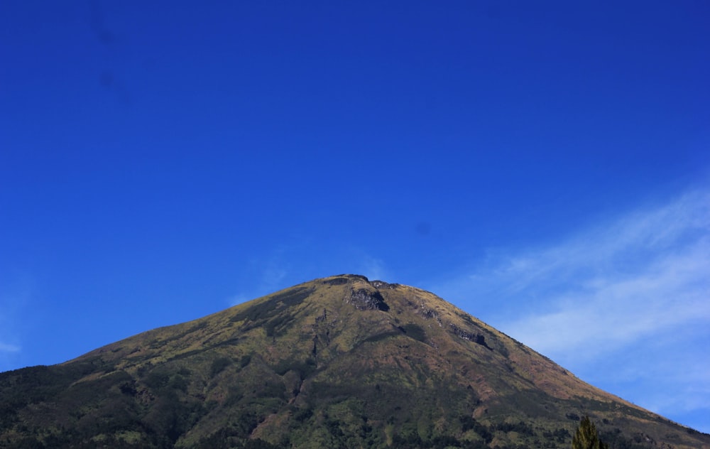 a very tall mountain with a blue sky in the background