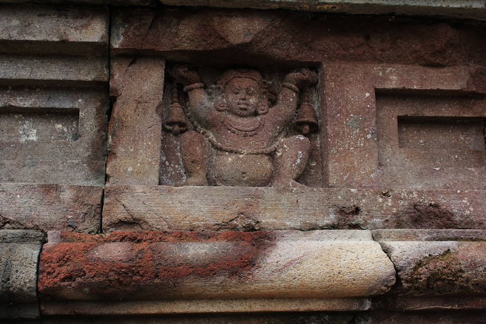 a stone carving of a buddha on a wall