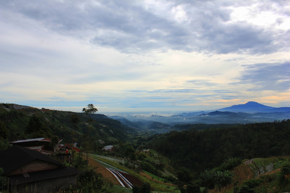 a scenic view of a valley with mountains in the background