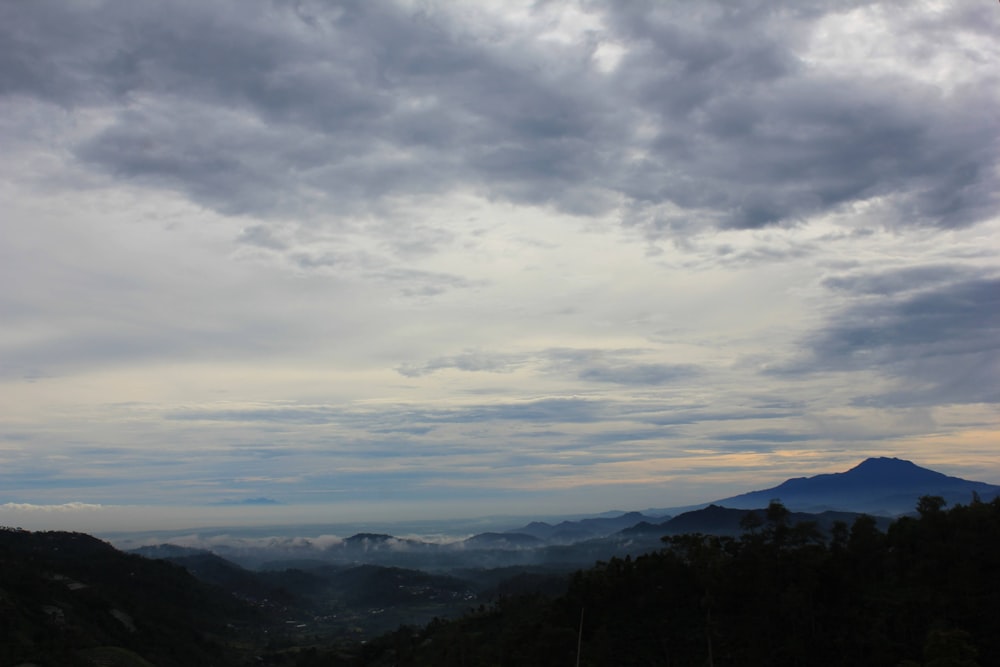 a view of a mountain range with clouds in the sky